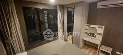 Cozy bedroom with modern decor and large window in stylish apartment.