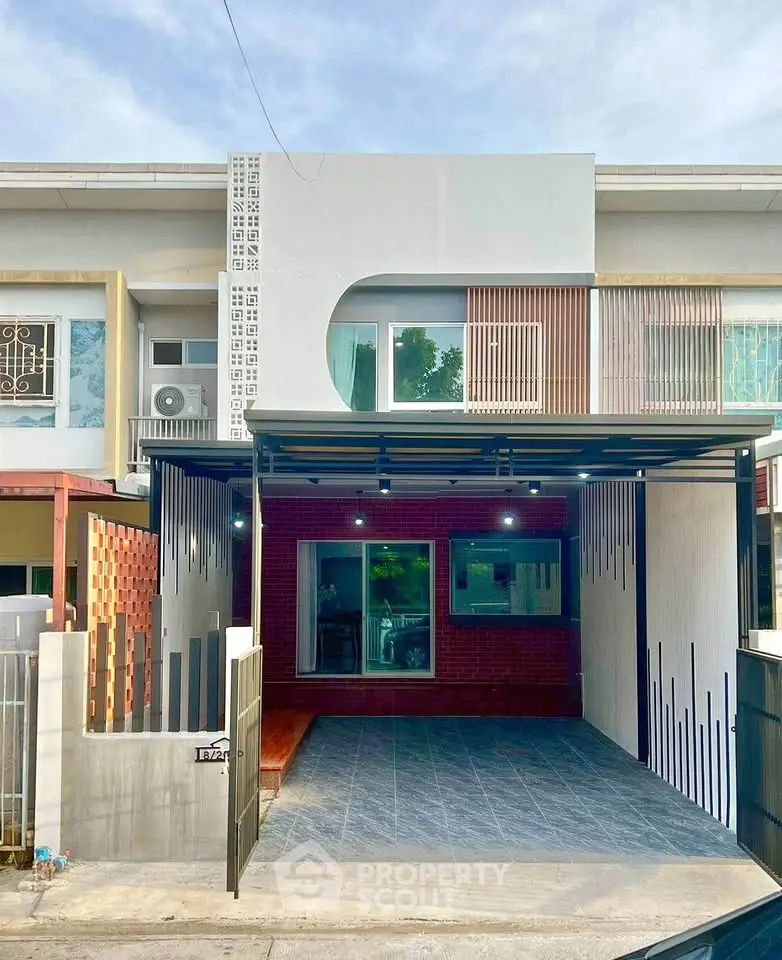 Modern townhouse exterior with unique geometric facade and spacious driveway.