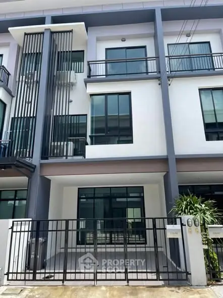 Modern townhouse exterior with sleek design and spacious balcony.