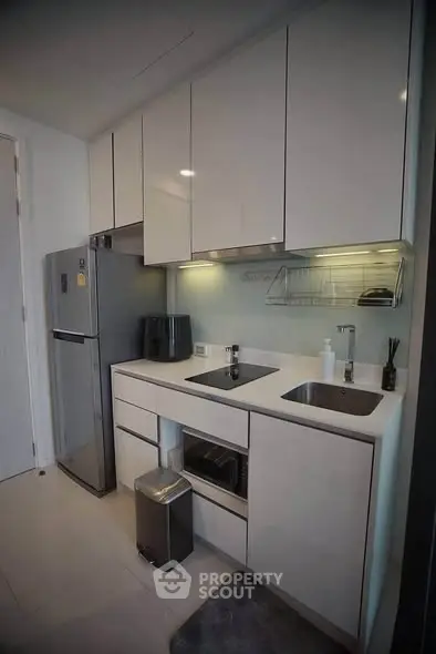 Modern kitchen with sleek cabinetry and stainless steel appliances in a compact layout.