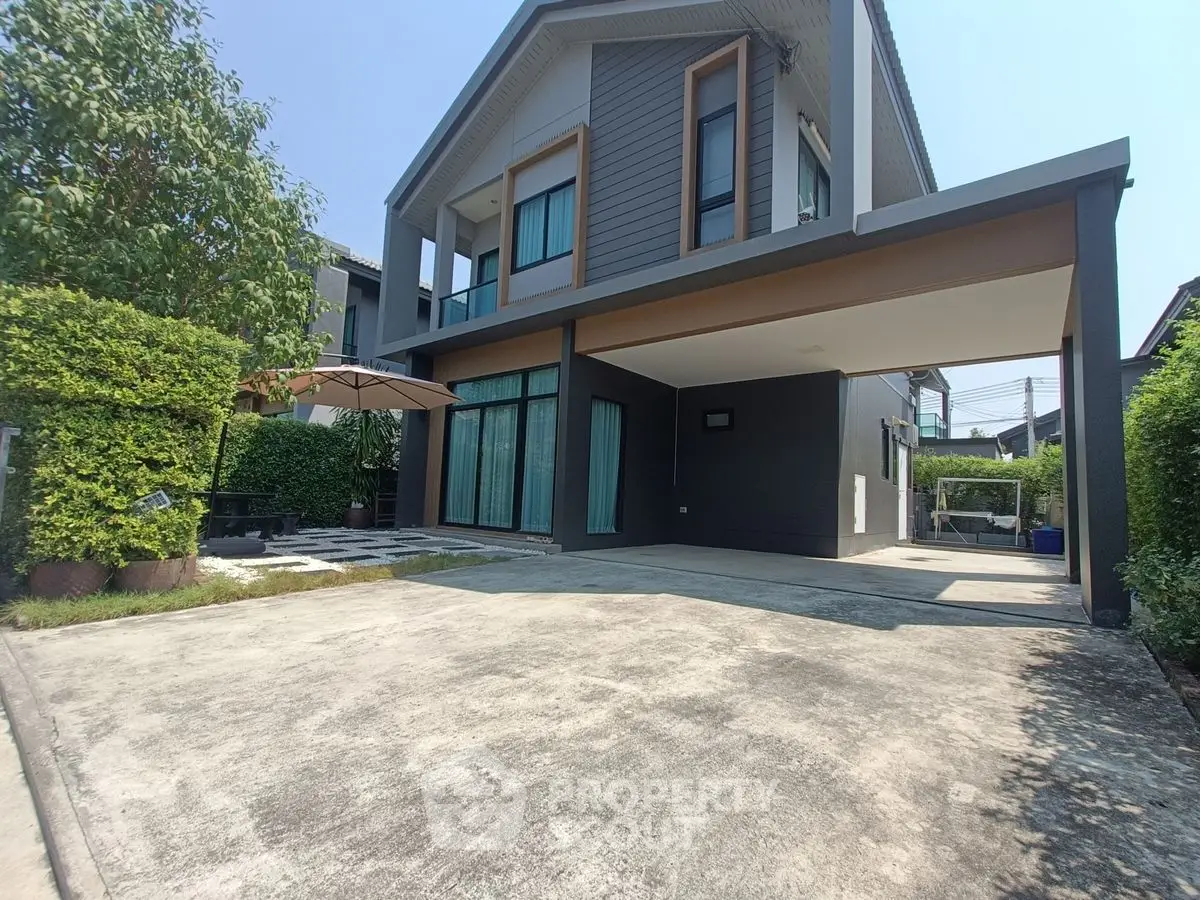 Modern two-story house with spacious driveway and lush greenery