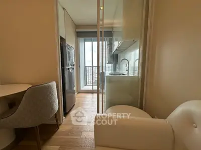 Modern compact kitchen with sleek appliances and a cozy dining area, featuring a view of the city skyline.