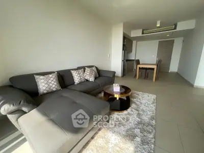 Spacious modern living room with elegant sofa and dining area, perfect for entertaining.