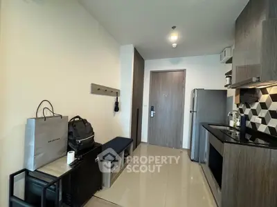 Modern kitchen with sleek cabinetry and stainless steel appliances in a compact apartment.