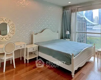 Elegant bedroom with city view, featuring classic white furniture and large window for natural light.