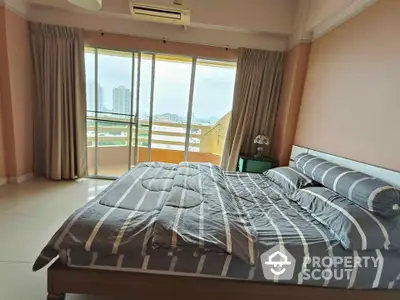 Spacious bedroom with large windows and city view, featuring modern decor and natural light.