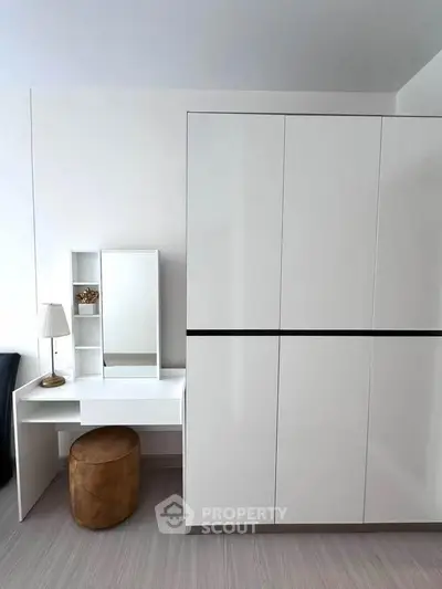 Modern bedroom with sleek white wardrobe and stylish vanity desk