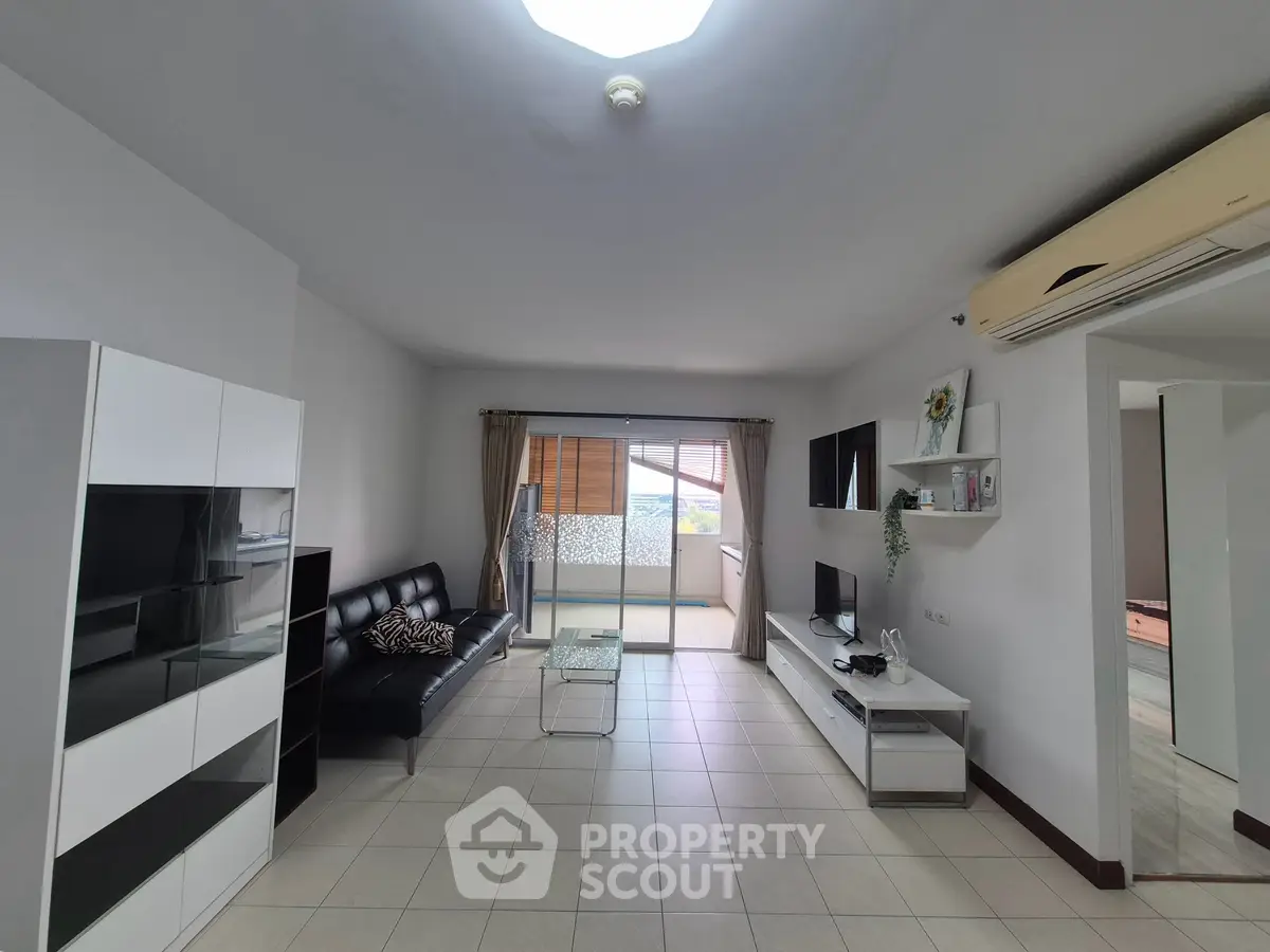 Spacious living room with modern furniture and balcony access in a stylish apartment.