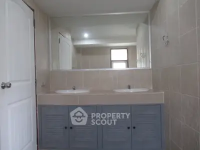 Spacious bathroom with dual sinks and large mirror in modern home