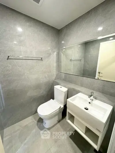 Modern bathroom with sleek gray tiles and contemporary fixtures.