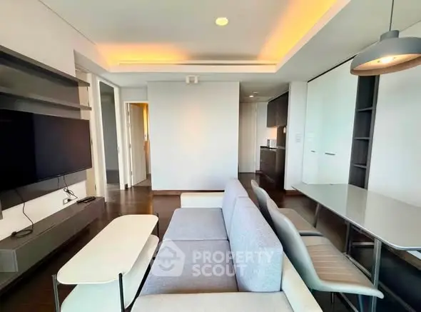 Modern living room with sleek furniture and open kitchen layout in a stylish apartment.