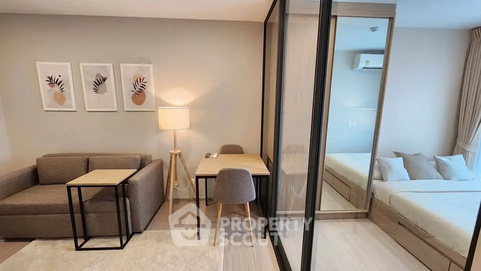 Modern studio apartment with cozy living area and glass partitioned bedroom