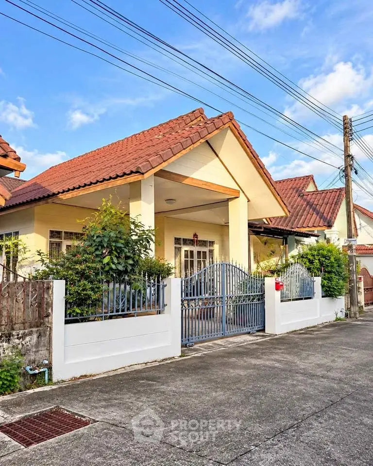 Charming suburban house with red-tiled roof and gated entrance, perfect for family living.