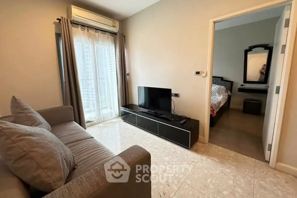 Modern living room with sleek furniture and natural light, adjacent to a cozy bedroom.