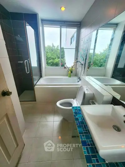 Modern bathroom with large window, bathtub, and stylish sink
