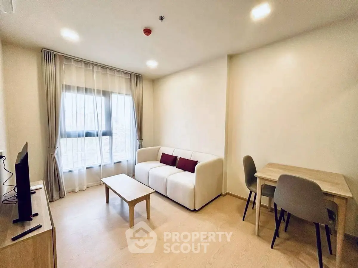 Modern living room with cozy sofa and dining area, featuring natural light and minimalist design.