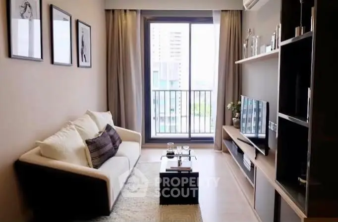 Stylish living room with balcony view, modern decor, and cozy ambiance.