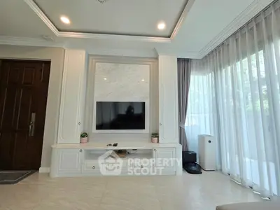 Elegant living room with modern TV setup and large windows