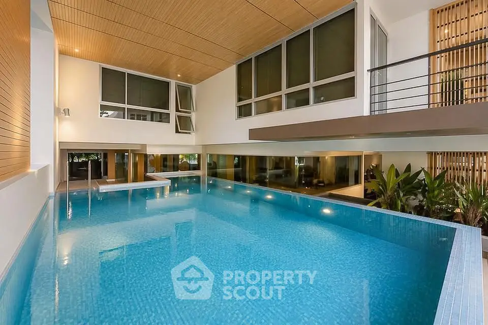 Luxurious indoor pool with modern architectural design and floor-to-ceiling windows.