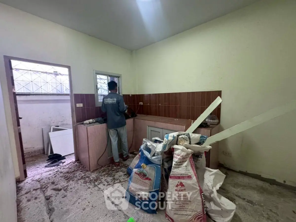 Under renovation kitchen with construction materials and worker