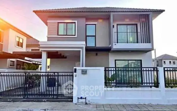 Modern two-story house with gated entrance and contemporary design.