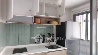 Modern kitchen with open cabinets, induction stove, and stainless steel fridge.