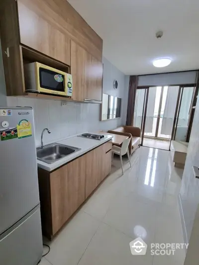 Modern kitchen with sleek cabinetry and dining area in a bright apartment