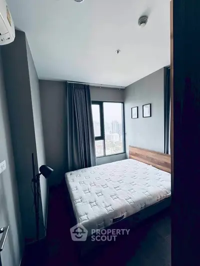 Cozy bedroom with city view, featuring a comfortable bed and modern decor.