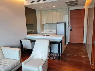 Modern open-layout kitchen and living area with sleek design and wooden flooring.