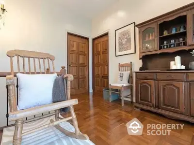 Charming interior with polished wooden floors, classic furniture, and a cozy rocking chair, perfect for a serene living experience.