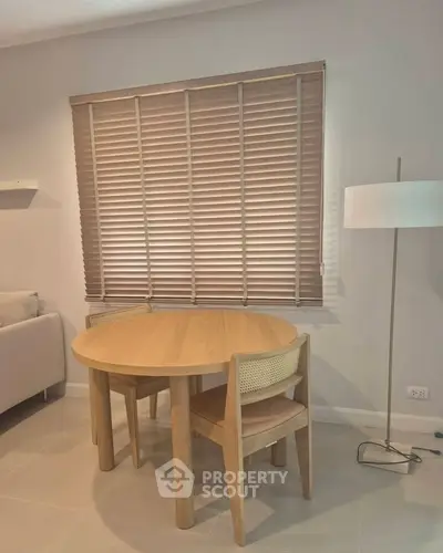 Cozy living room corner with round wooden table and chair, perfect for intimate gatherings.