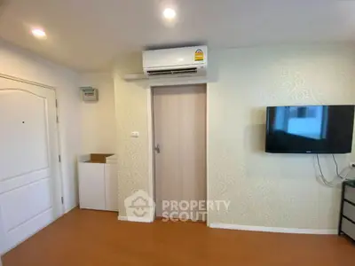 Modern living room with air conditioning and wall-mounted TV in stylish apartment.