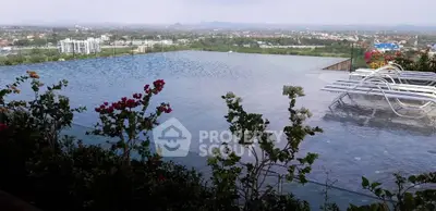 Stunning rooftop infinity pool with panoramic city views and lush greenery.