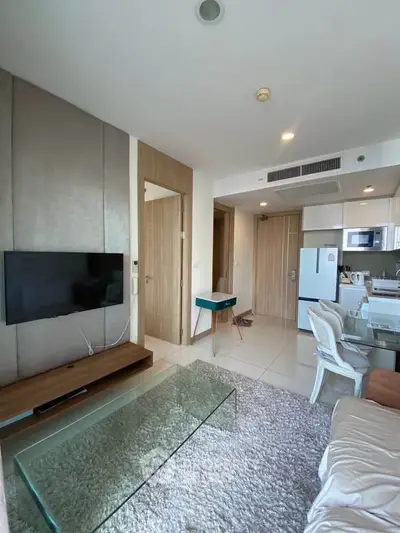 Modern living room with sleek furniture and open kitchen layout in a stylish apartment.