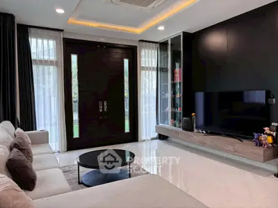 Modern living room with sleek design, large TV, and elegant furniture, perfect for relaxation and entertainment.