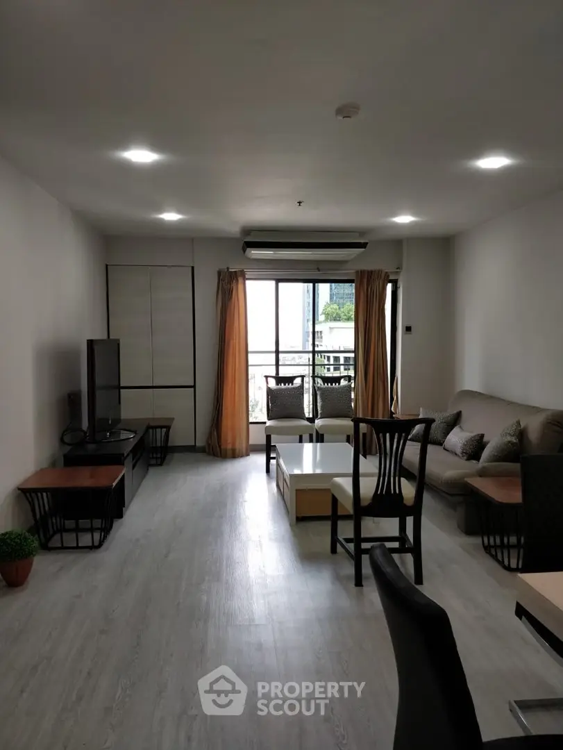 Spacious living room with modern furniture and large window offering natural light.