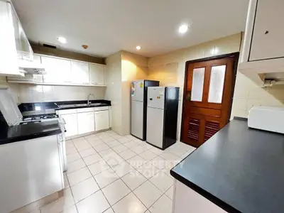 Spacious kitchen with modern appliances and sleek countertops in a well-lit setting.