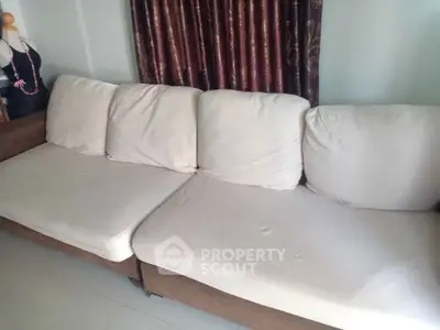 Spacious living room with comfortable beige sofa and elegant curtains