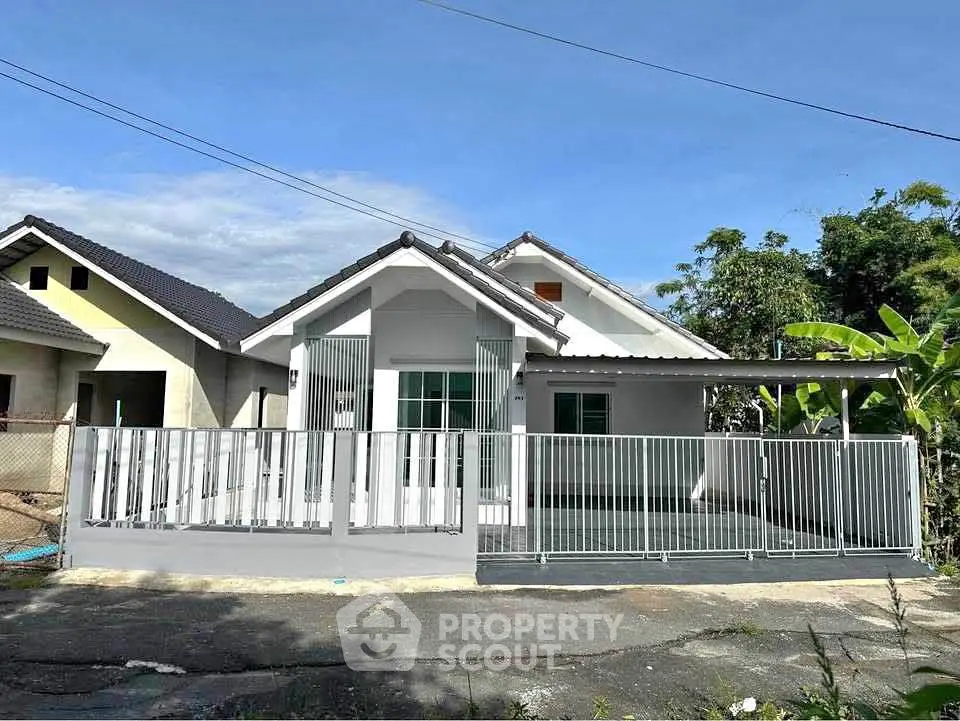 Charming single-story house with modern fence and lush greenery