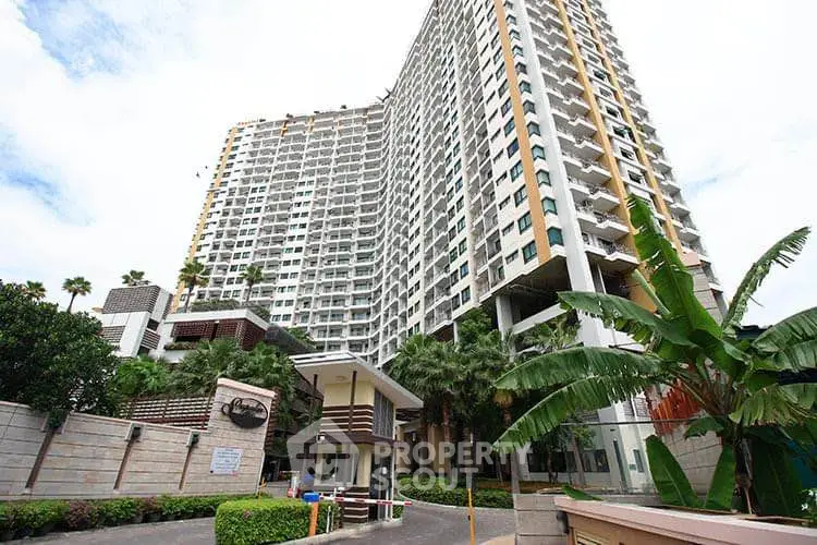 Modern high-rise condominium with lush greenery and secure entrance