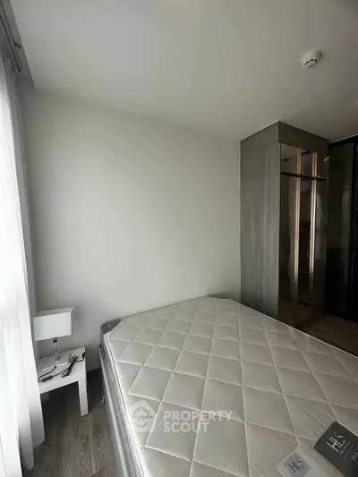 Modern bedroom with sleek wardrobe and natural light, perfect for urban living.