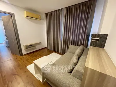 Modern living room with cozy sofa, wooden flooring, and elegant curtains in a stylish apartment.