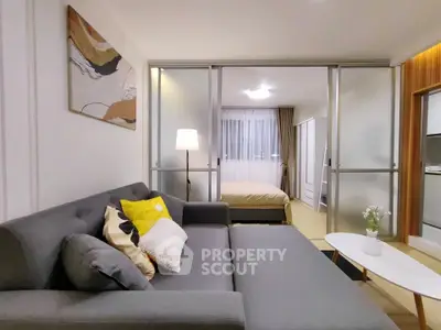 Modern living room with stylish decor and cozy bedroom view in open layout apartment.
