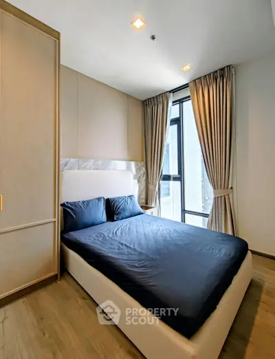 Modern bedroom with elegant design, featuring a large window and stylish curtains, perfect for relaxation.