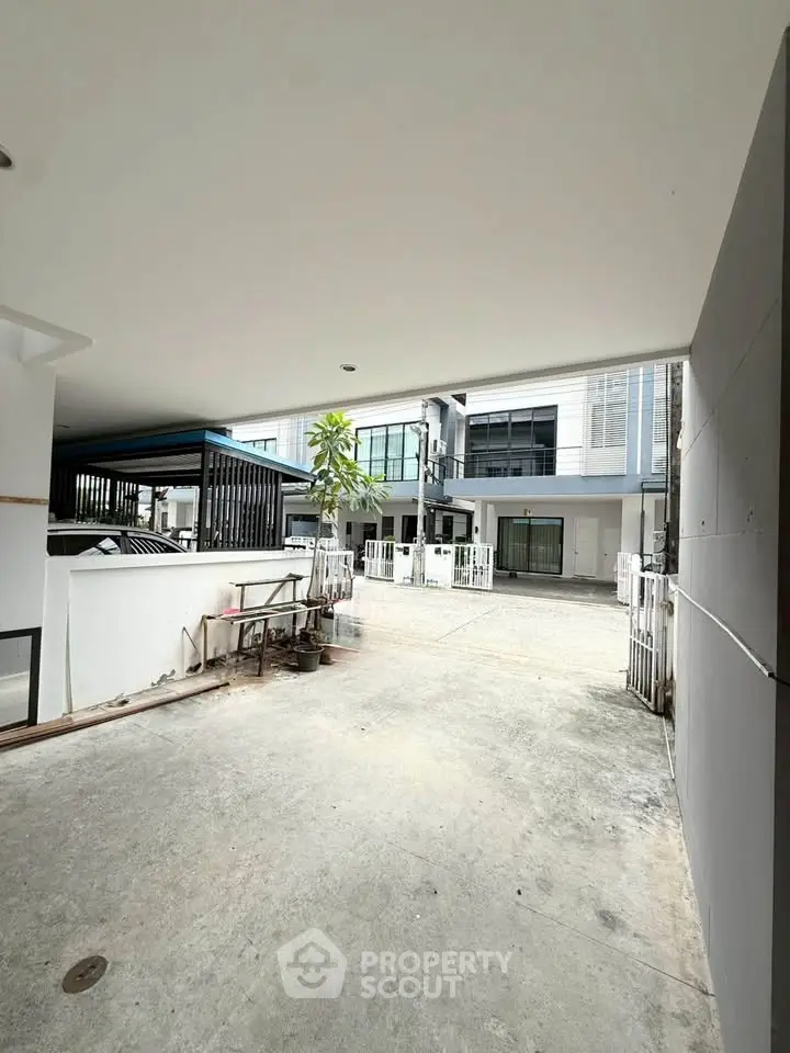 Modern townhouse exterior with spacious driveway and sleek architectural design.
