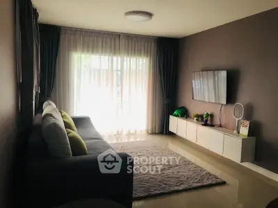 Modern living room with sleek furniture and large window for natural light.