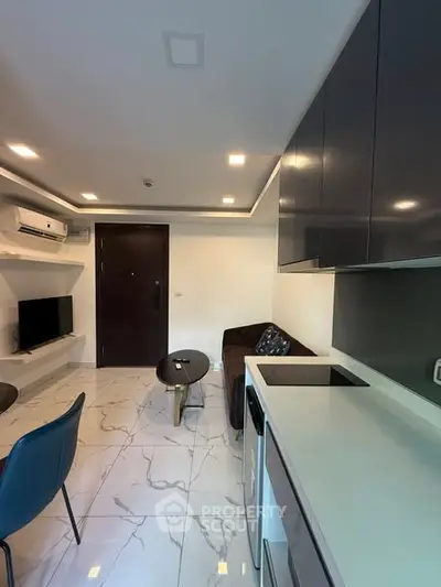 Modern living room with sleek kitchen and marble flooring in stylish apartment.