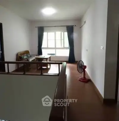 Spacious living area with natural light and simple furnishings