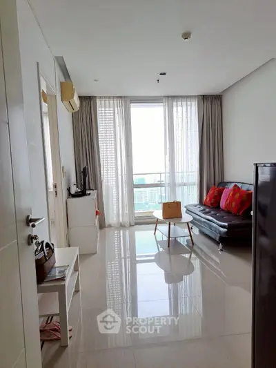 Modern living room with sleek furniture and large windows offering a stunning city view.