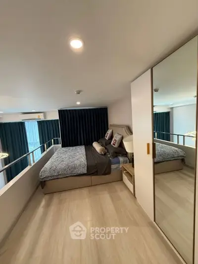 Modern bedroom with stylish decor and large mirror wardrobe